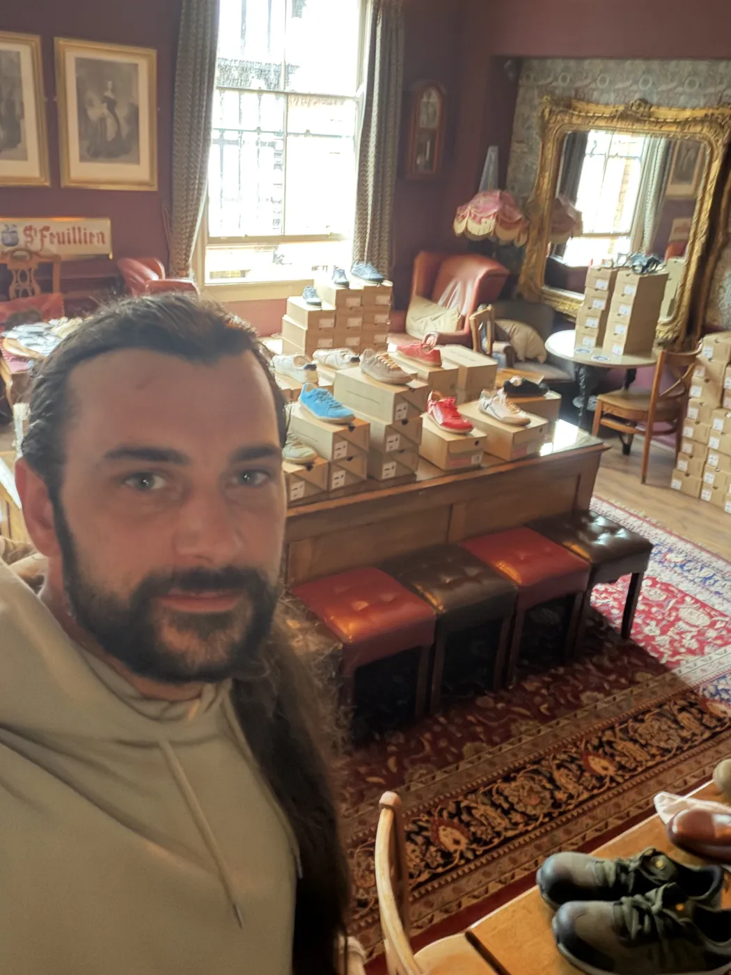 Dan taking a selfie in a grand old room full of shoe boxes and trainers on display
